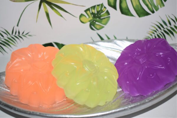 3 flower shaped soaps of orange, lemon and purple
